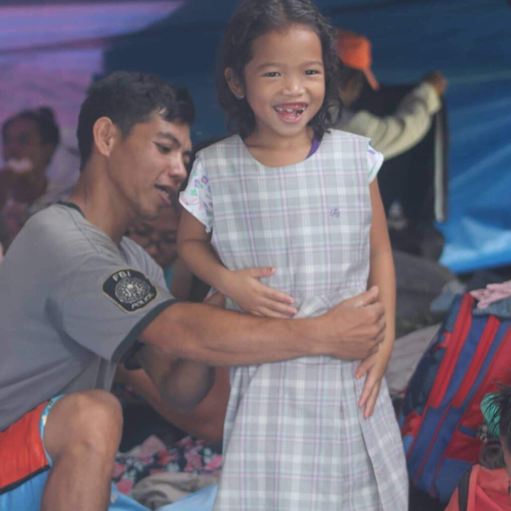 father and daughter receiving donated dress in kidapawan