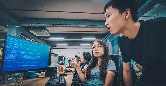 two coworkers looking at a monitor