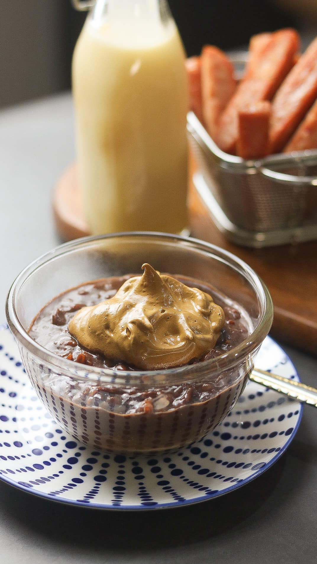 champorado topped with dalgona coffee, a bottle of milk, and spam fries