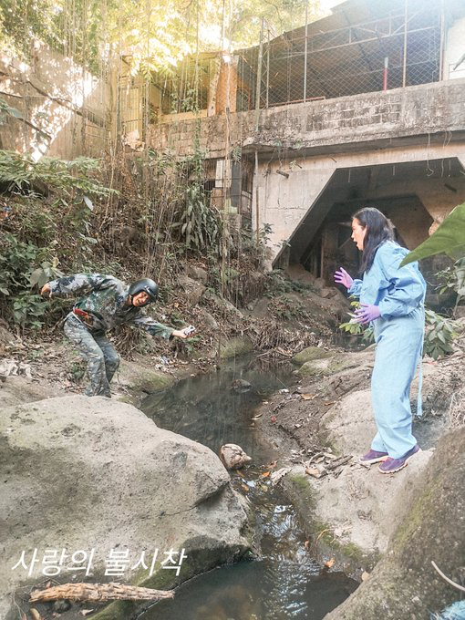 man dressed up as soldier and a woman separated by a creek