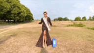 gif of Filipino in dress, sash, and crown with water and rice