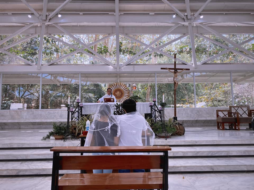 bride and groom in shirts and jeans, in front of priest