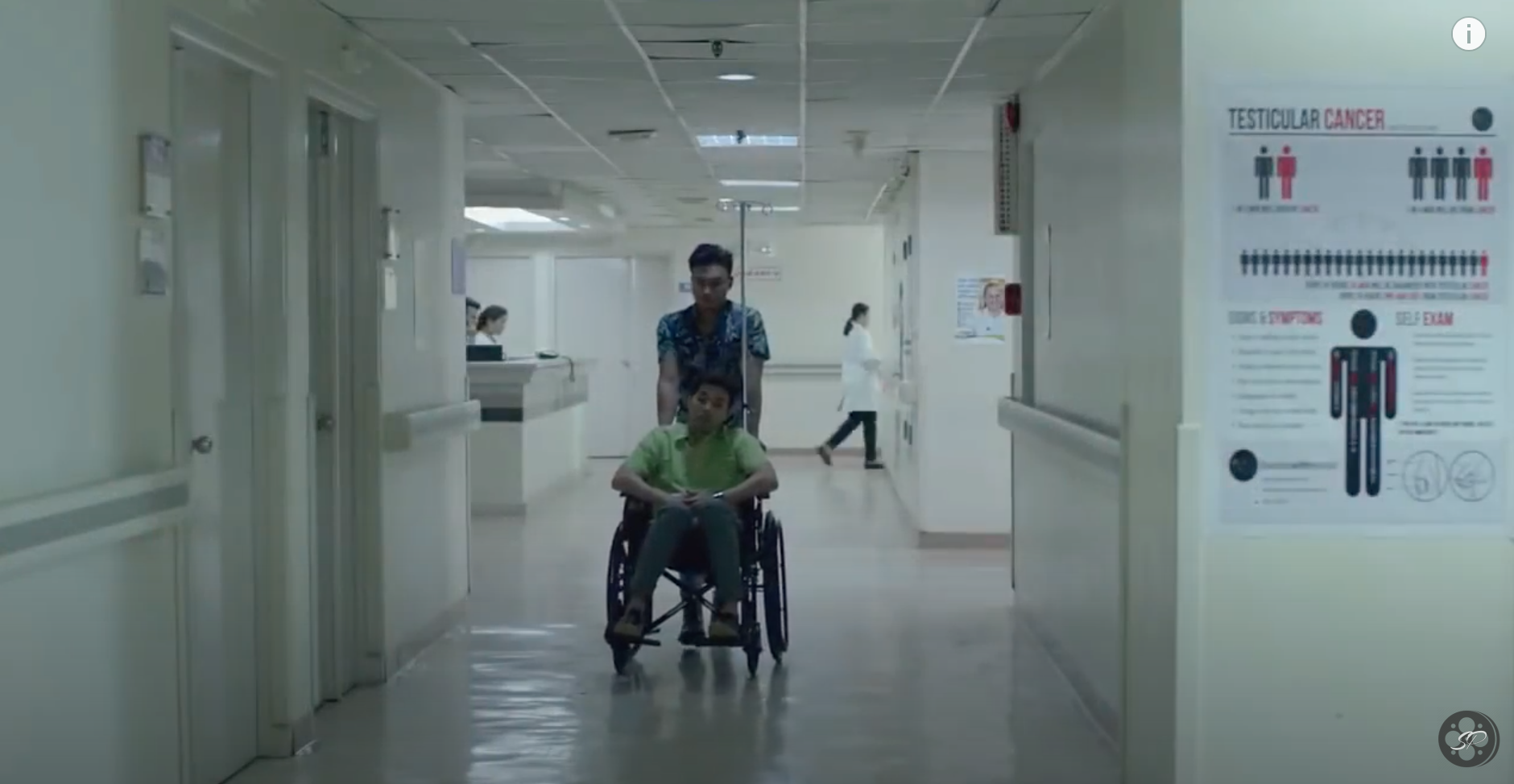 guy pushing another guy in a wheel chair in a hospital