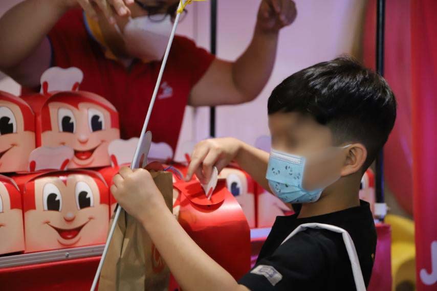 a kid getting his free Jollibee meal after vaccination